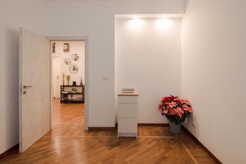a room with a white wall and a table and a plant at Pop Corn Vatican Suites in Rome