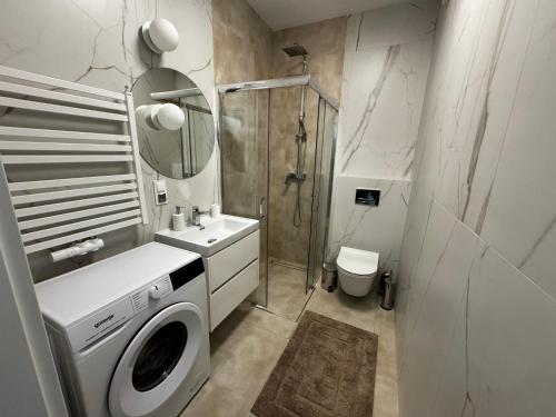 y baño con lavadora y ducha. en Apartament Moderato en Starogard Gdański
