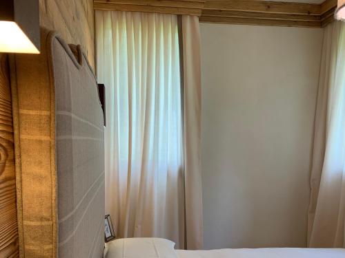 a bedroom with a bed and a curtain and a window at Piccolo gioiello di montagna in Villanova
