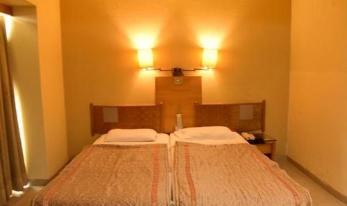Un pat sau paturi într-o cameră la FabHotel Prime Orchard Hospitality