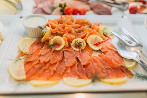 a plate of fish and vegetables on a table at DoubleTree by Hilton Hotel Cluj - City Plaza in Cluj-Napoca