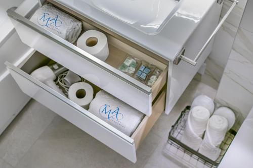 a drawer in a refrigerator filled with toilet paper at Melody Apartment in Novi Beograd