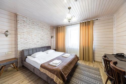 a bedroom with a bed and a table and a desk at Diamond Resort White in Bukovel