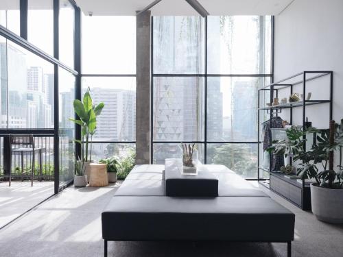 a large room with large windows with plants and a table at Lloyd's Inn Kuala Lumpur in Kuala Lumpur