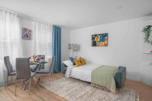 a bedroom with a bed and a table with chairs at Brick Lane, London - Lovely One Bedroom Apartment in London