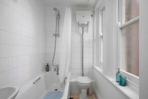 a bathroom with a toilet and a tub and a sink at Brick Lane, London - Lovely One Bedroom Apartment in London
