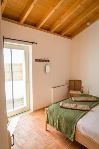 a bedroom with a bed and a large window at Costa Vicentina Villa with Garden Pool and View in Ermidas