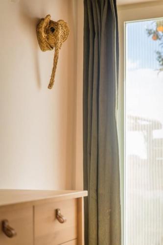 a mask hanging on a wall next to a window at Costa Vicentina Villa with Garden Pool and View in Ermidas