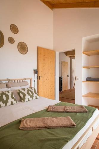 a bedroom with a bed with two towels on it at Costa Vicentina Villa with Garden Pool and View in Ermidas