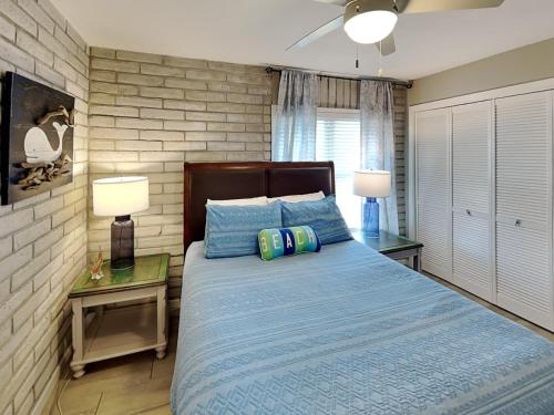 a bedroom with a blue bed with two tables and two lamps at Pearl- Marlin in Port Aransas