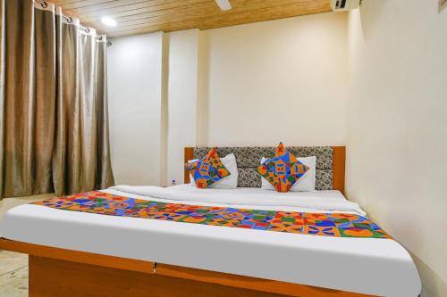 um quarto com uma cama grande e lençóis coloridos em HOTEL BRAHMASMI em Ujaim