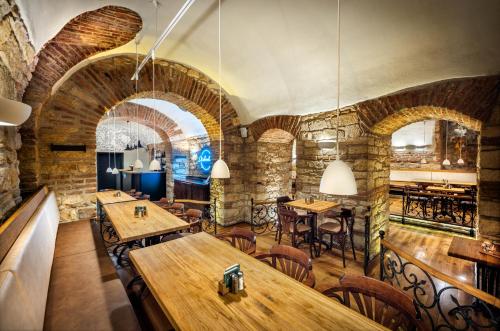 a restaurant with stone walls and wooden tables and chairs at Martin Hotel Prague in Prague
