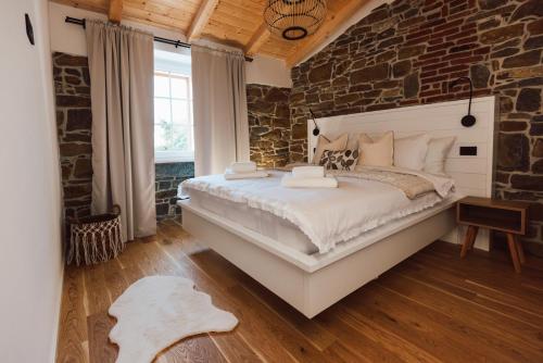 a bedroom with a large bed with a stone wall at Apartament VILLA SABAVIA in Gračišče
