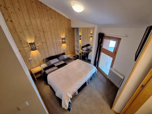 une chambre avec un grand lit et une fenêtre dans l'établissement Duplex La Plagne - Montchavin, 4 Pièces, 3 chambres, à La Plagne Tarentaise