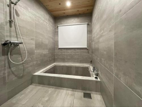 白馬的住宿－Atelier Hakuba，设有带浴缸和淋浴的浴室。
