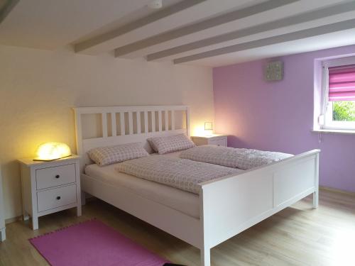 1 dormitorio con 1 cama blanca y 2 mesitas de noche en Gästehaus Bruch, en Kaisersbach