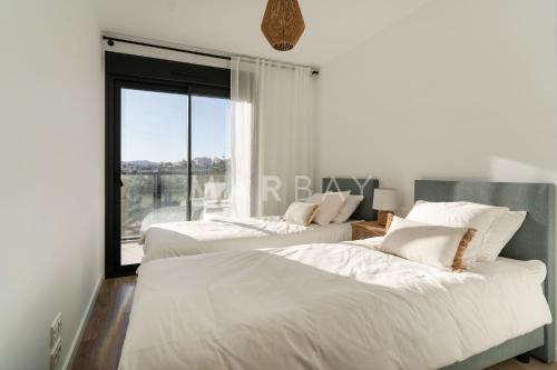 two beds in a bedroom with a window at Apartamento El Sueño in Jávea