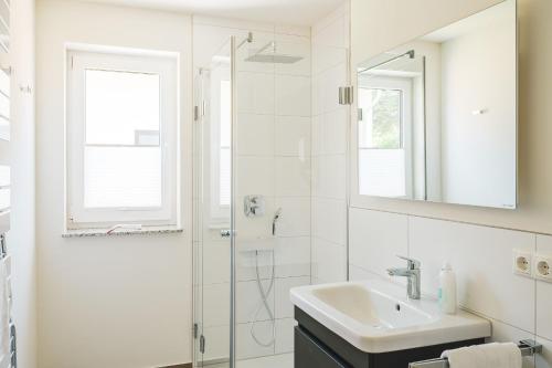 Dünenquartier Apartment 15 في زنغست: حمام أبيض مع حوض ودش