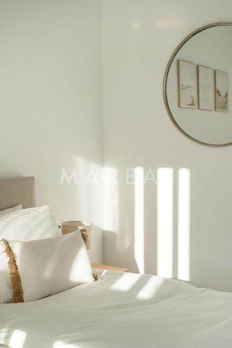 a bedroom with a white bed and a mirror at Apartamento El Sueño in Jávea