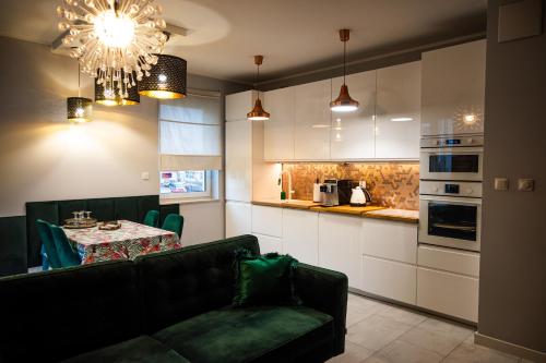 科希切日納的住宿－Apartament na Kaszubach，客厅配有沙发和餐桌,厨房配有桌子
