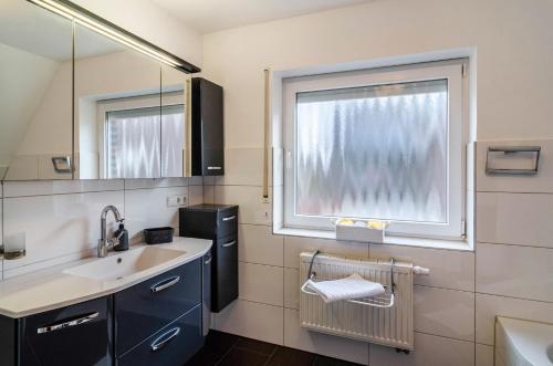 a bathroom with a sink and a window at Haus mit Garten und Kamin in Wilhelmshaven