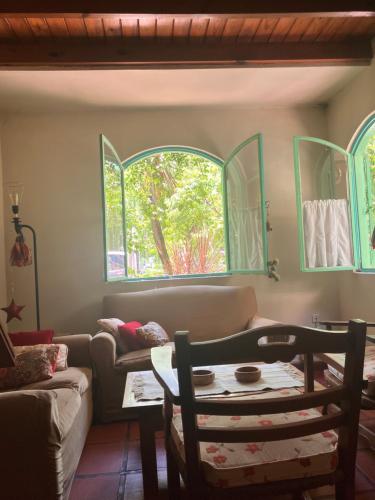 sala de estar con sofá y 2 ventanas en Cálida casa en barrio tranquilo cerca de la Laguna en Chascomús