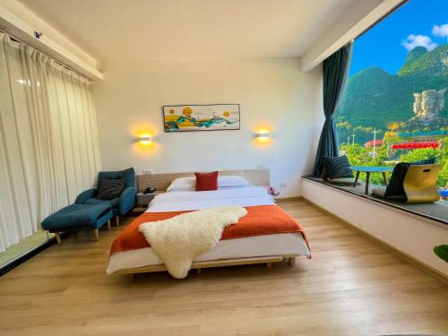 a hotel room with a bed and a large window at Sure I Do全景山宿 in Yangshuo