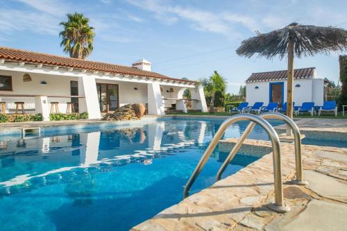 a swimming pool with an umbrella next to a house at Monte d'avo - Turismo rural- Casa Grande in Corgos