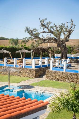 a resort with a swimming pool and a tree at Monte d'avo - Turismo rural- Casa Grande in Corgos