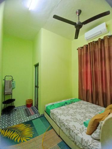 a bedroom with a bed and a ceiling fan at Raihan Homestay B Kubang Kerian,Free Wifi in Kota Bharu
