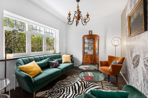 a living room with a green couch and a table at Hotel Torenhof in Sint-Martens-Latem