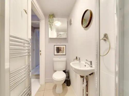 a white bathroom with a toilet and a sink at Pass the Keys Centrally located Victorian terrace Free parking in Cambridge