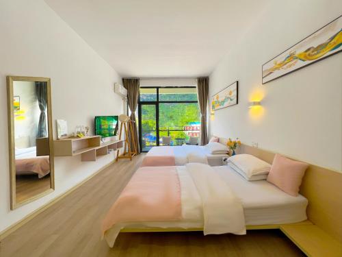 a bedroom with two beds and a mirror at Sure I Do全景山宿 in Yangshuo