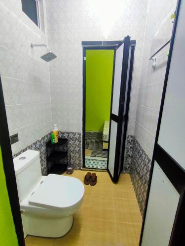 a bathroom with a toilet and a green mirror at Raihan Homestay B Kubang Kerian,Free Wifi in Kota Bharu