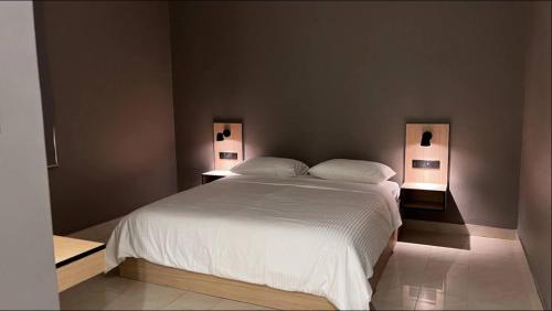 ein Schlafzimmer mit einem großen weißen Bett mit zwei Lampen in der Unterkunft Cozy Luxury 2 Bedroom Apartment Near Seaside in Kuwait