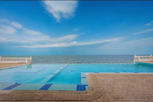 ein Schwimmbad mit dem Ozean im Hintergrund in der Unterkunft Cozy Luxury 2 Bedroom Apartment Near Seaside in Kuwait