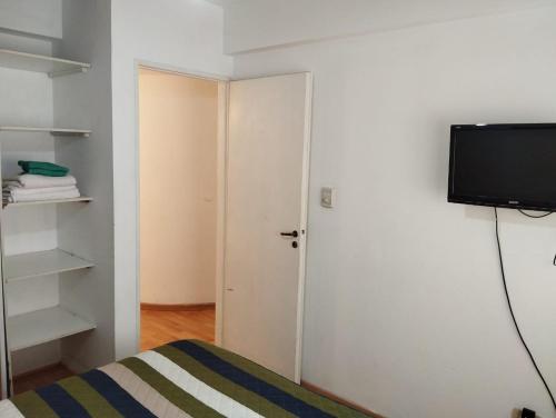 1 dormitorio con 1 cama y TV de pantalla plana en Moreno 186 en Rosario