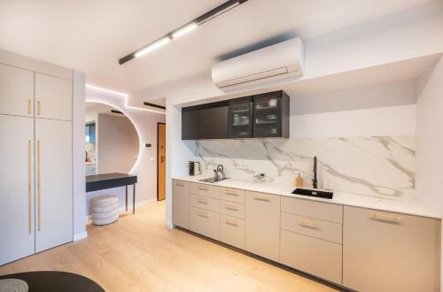 a kitchen with white cabinets and a sink at Solaris 711, sea view. in Darłowo