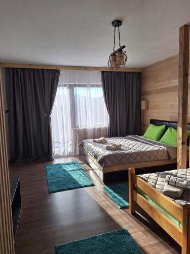 een slaapkamer met 2 bedden en groene tapijten bij Mrdja Apartments in Kolašin