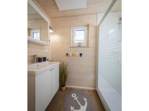 y baño con ducha y lavamanos. en Houseboat gray seal, en Heiligenhafen
