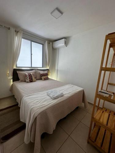 Schlafzimmer mit einem großen Bett und einem Fenster in der Unterkunft Apartamento do Sossego in São Luís