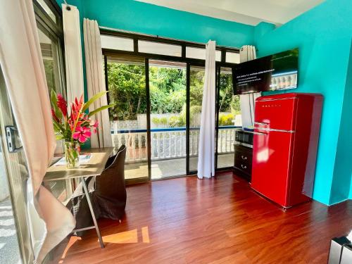una nevera roja en una cocina con mesa y ventana en Ngermid Oasis - Studio W/ Kitchenette & Pool View en Koror
