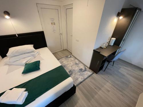 a hotel room with a bed and a desk and a room at Pensiunea Pictorilor in Baia Mare