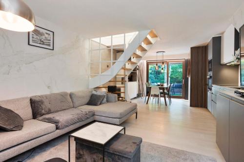 a living room with a couch and a staircase at Bos-Chalet bij Wijers Wandelroutes, Rust & Gezinsplezier Fijnspar 108 Hengelhoef in Houthalen-Helchteren