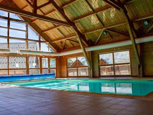 an indoor swimming pool with a wooden ceiling at Chalet La Joue du Loup, 3 pièces, 7 personnes - FR-1-504-45 in Le Dévoluy