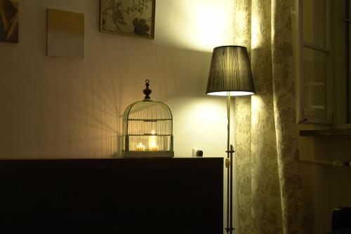 klatka dla ptaków siedząca na stole obok lampy w obiekcie Home in the Old Town w Warszawie