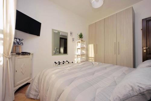a bedroom with a bed and a tv on the wall at Summer&Winter Home by the sea in Fiumicino
