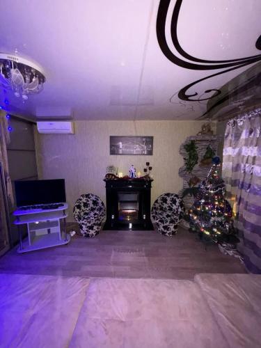 a living room with a christmas tree and a fireplace at Посуточно! Уютная, 1 квартира Олимпийская, новые дома. in Kharkiv