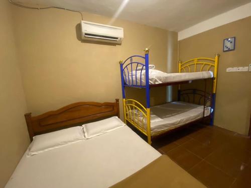 um quarto com 2 beliches e uma ventoinha em OYO 90910 Homestay D Lalang Inn em Kuah