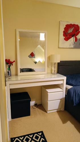 a bedroom with a desk with a mirror and a bed at Ensuite Double Bedroom in a 2 bed Spacious Apartment in Warrington